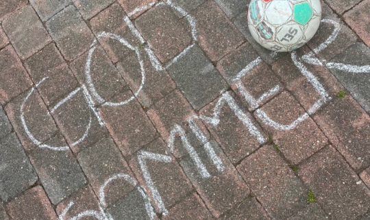 Skrift på steinheller og en fotball.